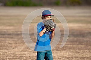 Cute young boy playing baseball outdoors