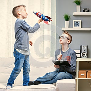 Cute young boy playing with a toy rocket on a sofa