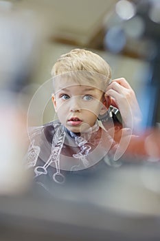 Cute young boy is scared of haircut