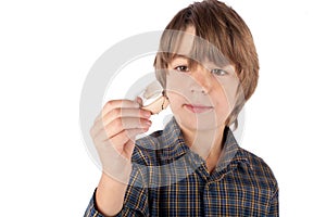 Cute young boy showing a hearing aid. Isolated on white background.