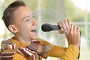 Cute young boy singing into a microphone