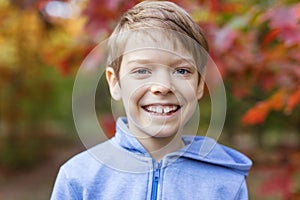 Cute young boy smiling on walk in autumn park