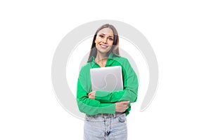 cute young brown-eyed brown-haired careerist woman with makeup in a green blouse works remotely in the IT field