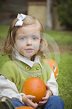 Cute Young Child Girl Enjoying the Pumpkin Patch.