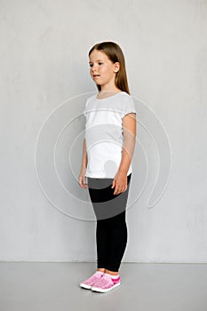 Cute young child with long hair in white t-shirt and black sweatpants