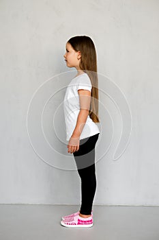 Cute young child with long hair in white t-shirt and black sweatpants