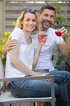 cute young couple drinking red wine in garden