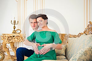 Cute young couple embracing tenderly pregnant tummy.