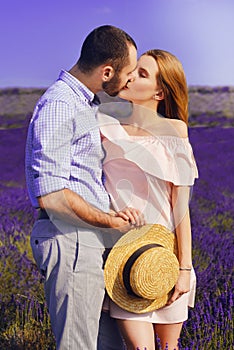 Cute young couple in love in a field of lavender flowers. Enjoy a moment of happiness and love in a lavender field. kiss