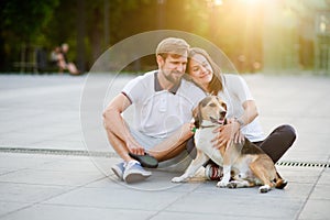 Cute young couple sits on the earth closely having nestled to each other.