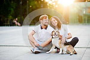 Cute young couple sits on the earth closely having nestled to each other.