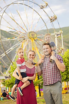 Cute young family enjoying a day at amusement park