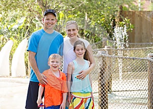 Beautiful young family enjoying a day at an outdoors amusement park