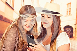 Cute young fashionable girls using cell phone