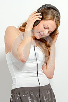 Cute young female listens to headphones