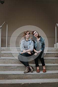 Cute Young Female Musician Friends Modeling Outside on Concrete Steps