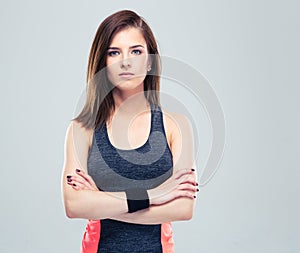 Cute young fitness woman with arms folded