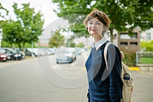 Cute young girl with a backpack heading to school on warm autumn morning. Child going back to school