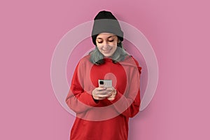 Cute young girl with blue hair using mobile phone