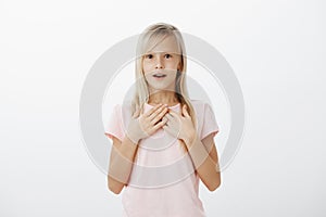 Cute young girl dreams become actress when grow up. Indoor shot of surprised amazed adorable child with fair hair