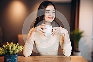 Cute young girl is drinking tea coffee at home while working studying. Freelancer female. Student girl