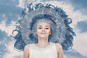 Cute young girl with gorgeous blue hair against a cloudy sky