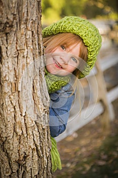 Cute Young Girl in Green Scarf and Hat Plays Peekaboo