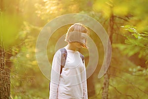 Cute young girl having fun during forest hike on beautiful summer day. Child exploring nature