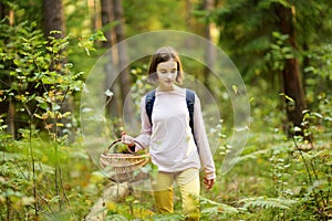 Cute young girl having fun during forest hike on beautiful summer day. Child exploring nature