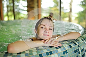 Cute young girl having fun in indoor pool. Child learning to swim. Kid having fun with water toys. Family fun in a pool