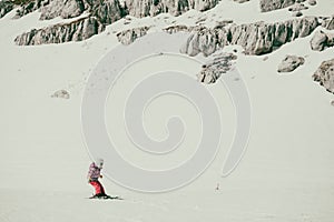 Cute young girl learning to skii at winter resort on a sunny day.