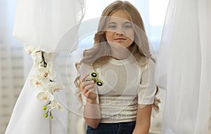 Cute young girl playing with fidget spinner in bright room