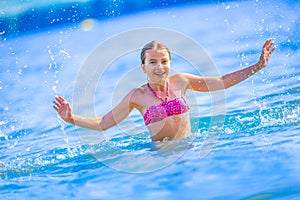 Cute young girl playing in the sea. Happy pre-teen girl enjoys summer water and holidays in holiday destinations