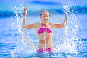 Cute young girl playing in the sea. Happy pre-teen girl enjoys summer water and holidays in holiday destinations