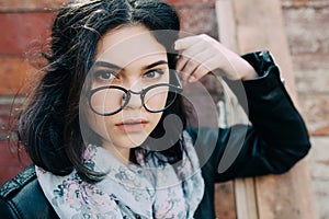 Beautiful happy hipster girl goes in the city. Closeup of trendy girl face.