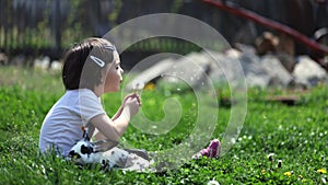 Cute young girl with rabbit blowing a dandelion