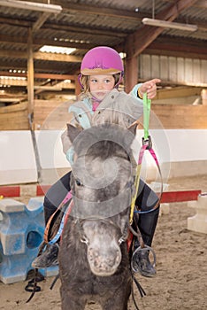 cute young girl riding her pony before riding lesson