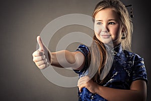 Cute young girl showing thumbs up