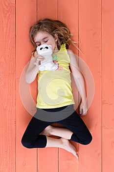 Cute young girl sleeping with her plush toy cat
