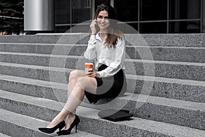 Cute young girl smiling sits and talking by phone