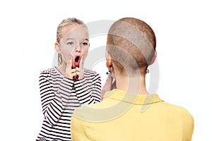 Cute young girl with speech therapist practicing correct pronunciation. Child speech therapy concept on white background.