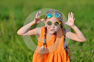 Cute young girl in sun glasses hamming having fun outdoors. photo