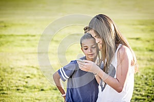 Cute young girls watching viral social media video on mobile cell phone outdoors