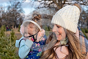 Cute young mother and daughter in winter