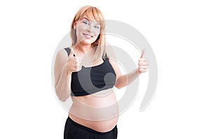 Cute young pregnant girl pointing finger to the camera