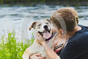 Cute young retriever in hands of his owners