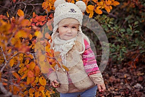 Cute young russian baby girl stylish dressed in warm white fur handmade jacket blue jeans boots and hooked hat teddy bear posing i photo