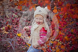Cute young russian baby girl stylish dressed in warm white fur handmade jacket blue jeans boots and hooked hat teddy bear posing i photo