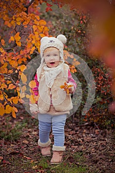 Cute young russian baby girl stylish dressed in warm white fur handmade jacket blue jeans boots and hooked hat teddy bear posing i photo