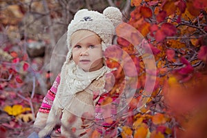 Cute young russian baby girl stylish dressed in warm white fur handmade jacket blue jeans boots and hooked hat teddy bear posing i photo